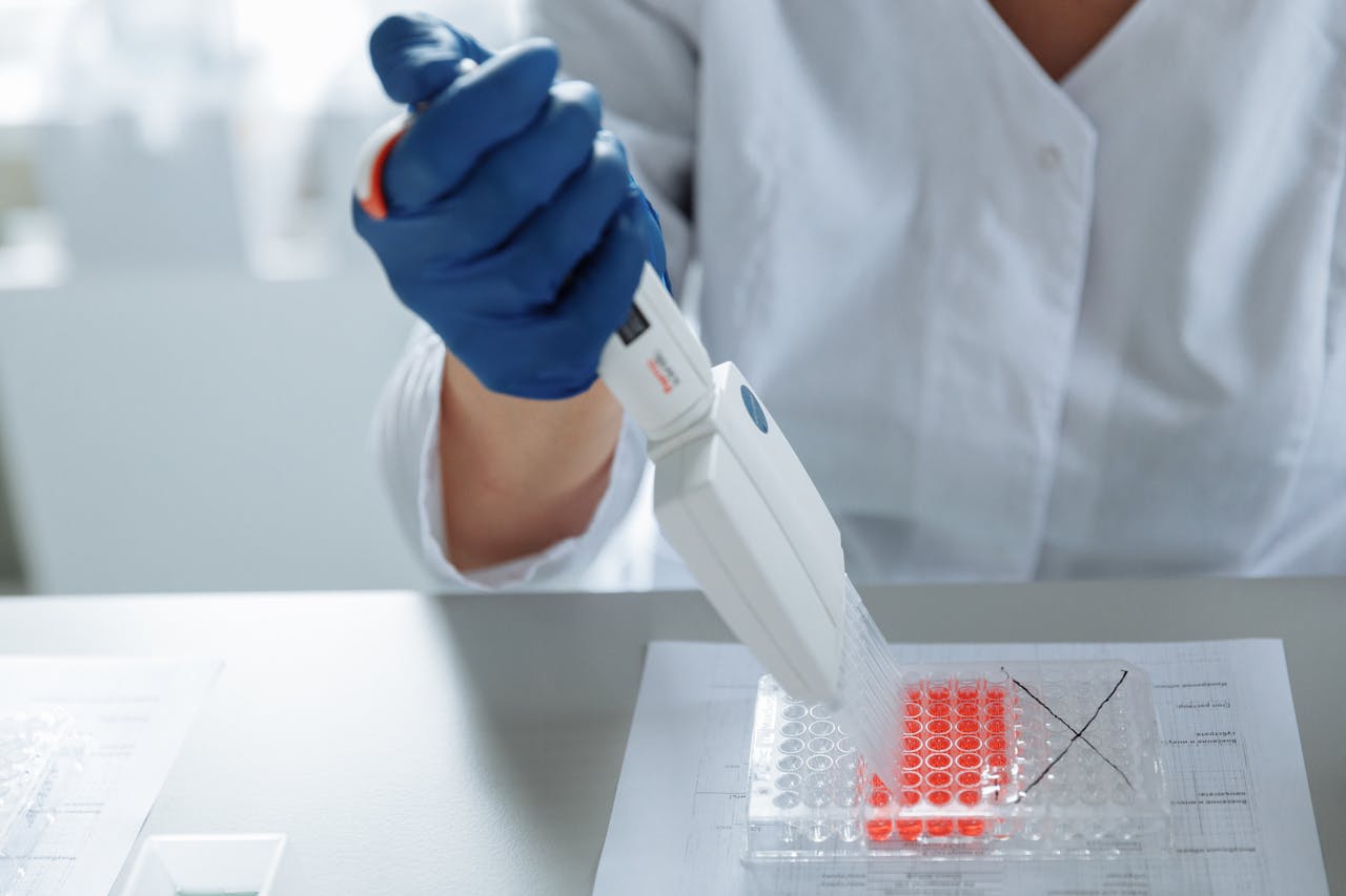 hero-img-02 Close-up of a scientist using a pipette in a lab with a focus on sterile procedures.